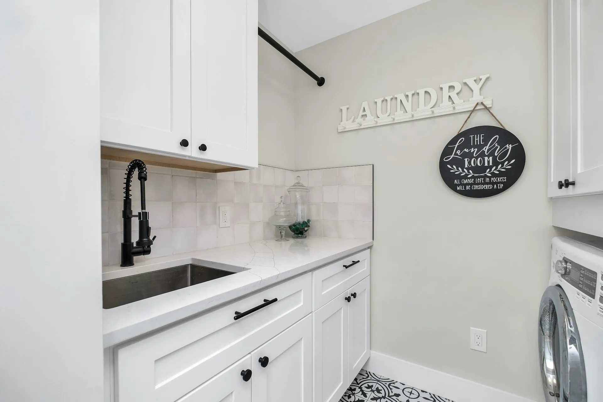 White shaker cabinets with quartz counters in a laundry room